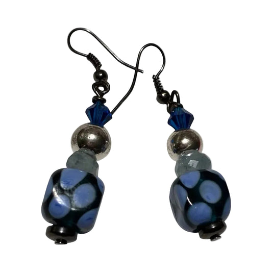 Pair of earrings with blue and black beads on a white background